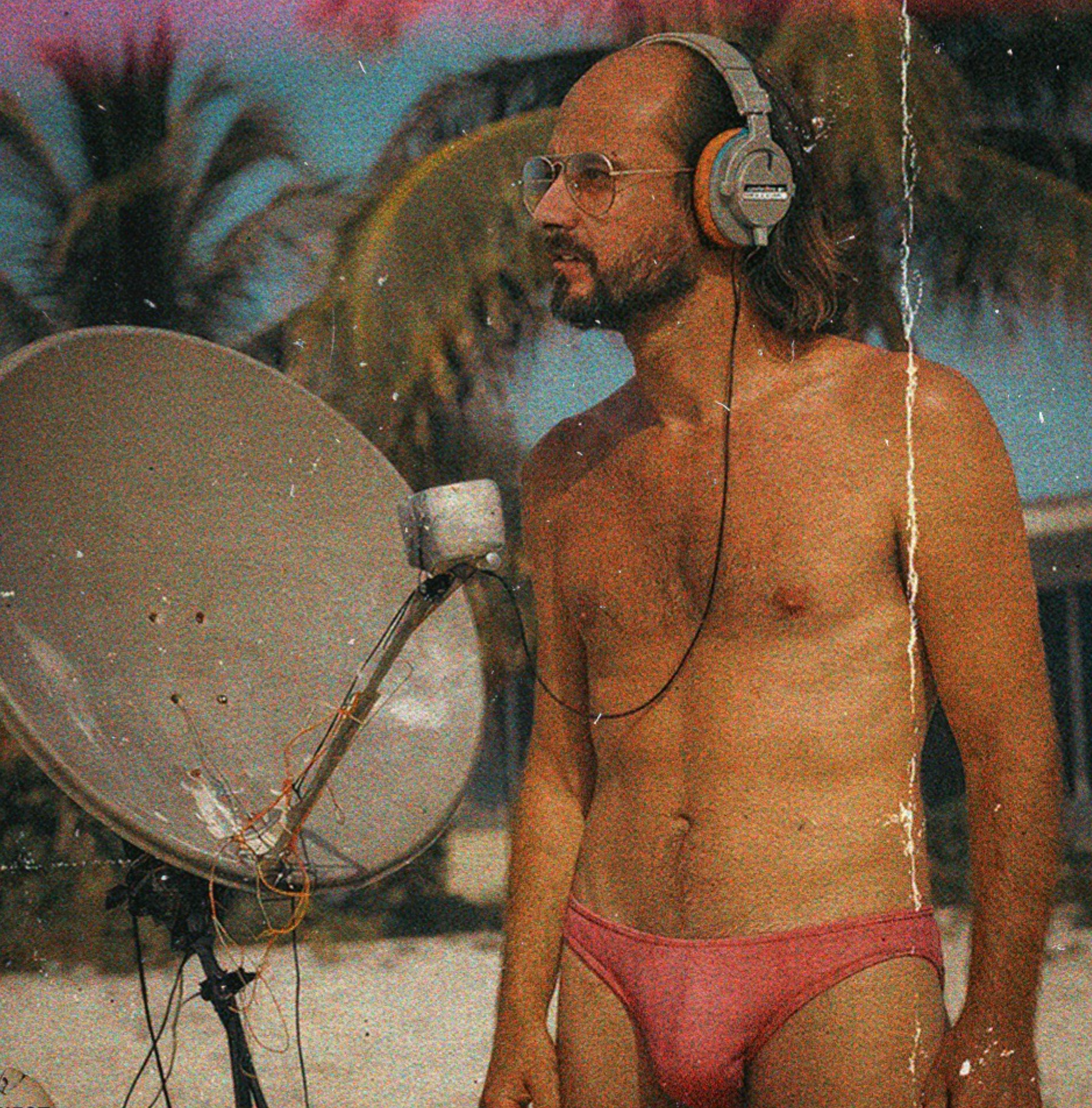 Bill listening through headphones beside a homemade dish antenna